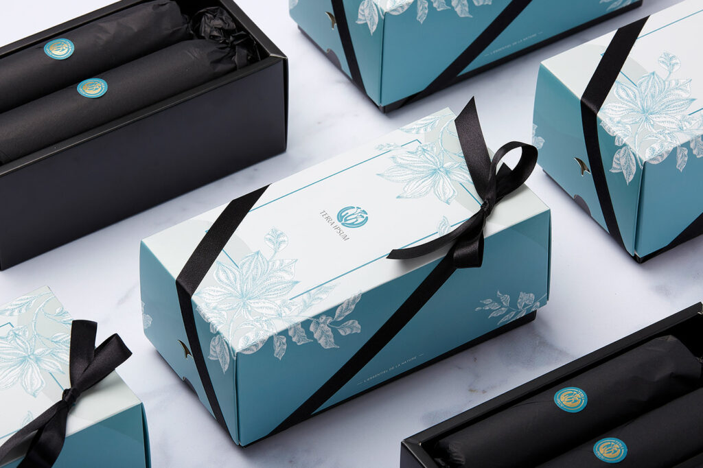 來自法國的有機天然品牌TERRA iPSUM，其品牌秉持著有機、天然，且對環境友善的品牌理念；禮盒包裝也延續此核心，從視覺設計至材質應用皆呈現天然與環保的概念；以品牌標準色搭配純黑色為色彩定調，成為一款Ti的經典禮盒。盒型選擇天地蓋的方式設計，在開闔的感受上更讓人有送禮的感覺，而在蓋上後露出一點底盒的黑，一來為了內容物數量的變化考量給予彈性，二來讓整體包裝更有層次；外盒上下以品牌輔助圖形簍空露出黑色底盒，亦讓禮盒整體更加豐富。